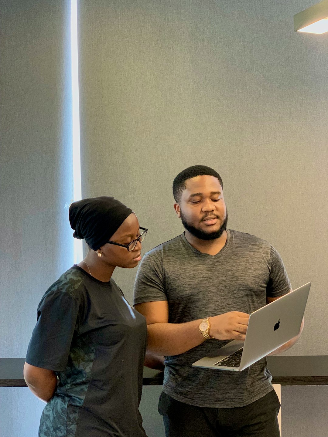 a man and woman looking at a laptop